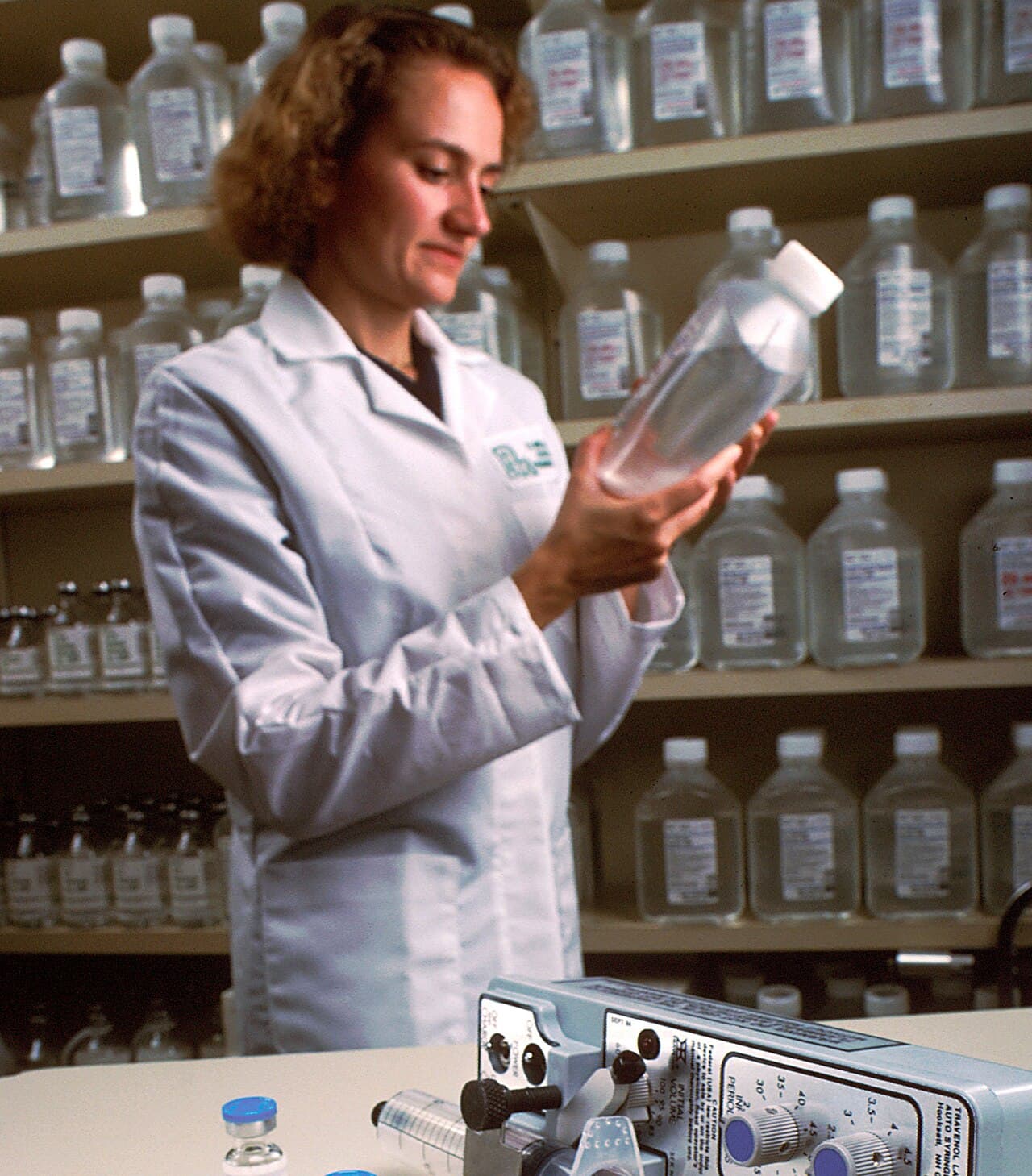 A pharmacist examining a liquid medicine in a hospital pharmacy